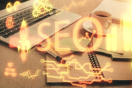 Double exposure of SEO writing and desktop with coffee and items on table background. Concept of search optimization.の写真素材