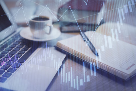 Double exposure of forex chart drawing and desktop with coffee and items on table background. Concept of financial market tradingの写真素材