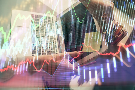 Double exposure of businesswoman hands typing on computer and financial graph hologram drawing. Stock market analysis concept.の写真素材