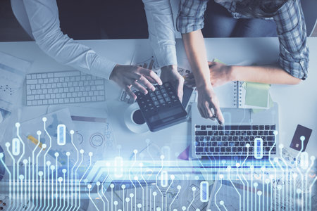 Double exposure of man and woman working together and data theme hologram drawing. Computer background. Top View.の写真素材