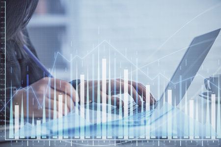 Double exposure of businesswoman hands typing on computer and forex graph hologram drawing. Financial analysis concept.の写真素材