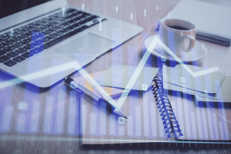 Multi exposure of forex graph drawing and desktop with coffee and items on table background. Concept of financial market tradingの写真素材