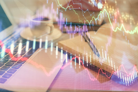 Double exposure of financial chart drawing and desktop with coffee and items on table background. Concept of forex market tradingの写真素材