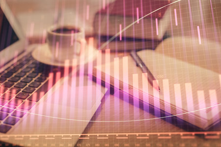 Double exposure of financial chart drawing and desktop with coffee and items on table background. Concept of forex market tradingの写真素材