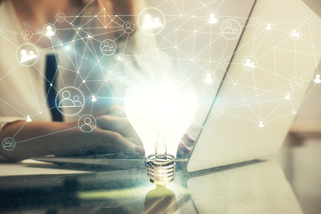 Double exposure of woman hands typing on computer and light bulb drawing. Idea concept.の写真素材