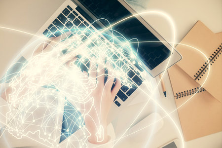 Double exposure of woman hands working on computer and financial theme hologram drawing. Top View. Business concept.の写真素材