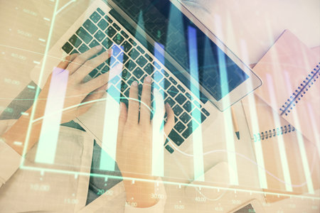 Double exposure of woman hands working on computer and forex graph hologram drawing. Top View. Financial analysis concept.の写真素材