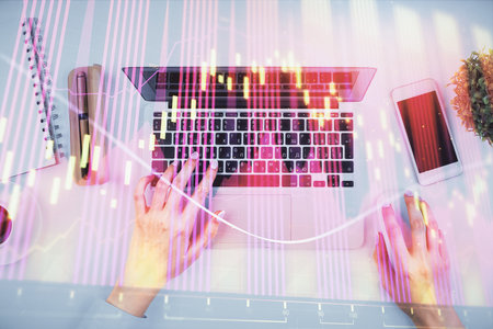 Double exposure of woman hands working on computer and forex chart hologram drawing. Top View. Financial analysis concept.の写真素材