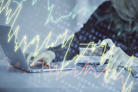 Double exposure of woman on-line shopping holding a credit card and financial graph drawing. Stock market E-commerce concept.の写真素材
