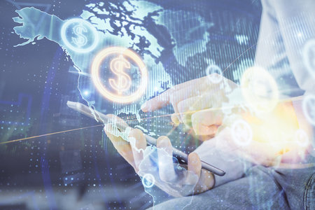 Double exposure of man's hands holding and using a digital device and forex graph drawing. Financial market concept.の写真素材