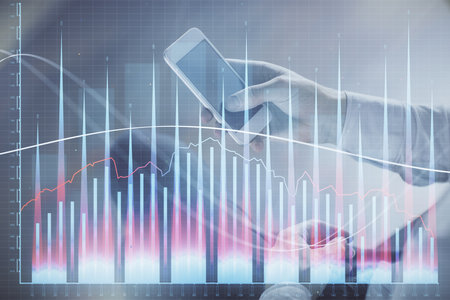 Double exposure of man's hands holding and using a digital device and forex graph drawing. Financial market concept.の写真素材