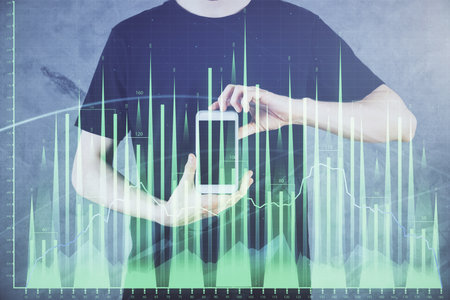 Double exposure of man's hands holding and using a digital device and forex graph drawing. Financial market concept.の写真素材