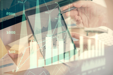 Double exposure of man's hands holding and using a phone and financial chart drawing. Market analysis concept.の写真素材