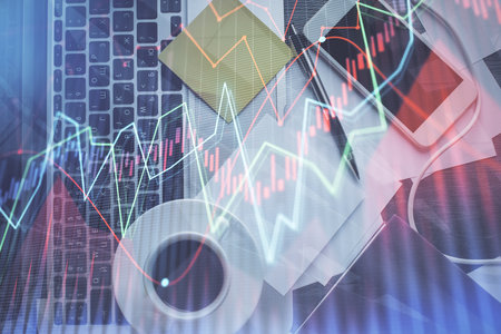 Double exposure of financial chart drawing over table background with computer. Concept of research and analysis. Top view.の写真素材