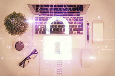 Double exposure of lock hologram drawing over study table background with computer. Concept of data security. Top view.の写真素材