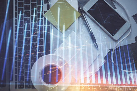 Double exposure of financial chart drawing over table background with computer. Concept of research and analysis. Top view.の写真素材