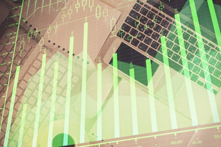 Financial market graph and top view computer on the desktop background. Multi exposure. Investment concept.の写真素材