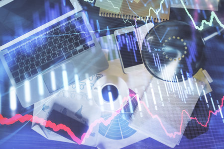 Financial market graph and top view computer on the desktop background. Multi exposure. Investment concept.の写真素材