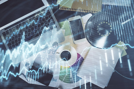 Financial market graph and top view computer on the desktop background. Multi exposure. Investment concept.の写真素材