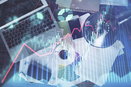 Financial market graph and top view computer on the desktop background. Multi exposure. Investment concept.の写真素材