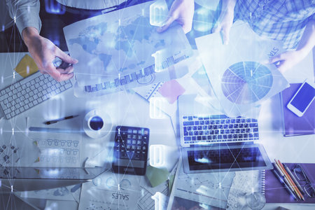 Double exposure of man and woman working together and data theme hologram drawing. Computer background. Top View.の写真素材