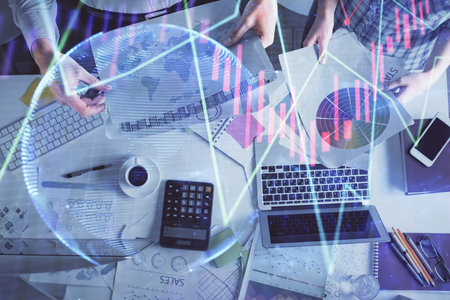 Double exposure of man and woman working together and financial chart hologram drawing. market analysis concept. Computer background. Top View.の写真素材