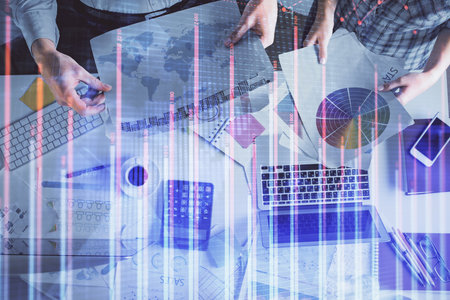 Double exposure of man and woman working together and financial chart hologram drawing. market analysis concept. Computer background. Top View.の写真素材
