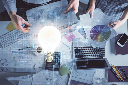 Double exposure of man and woman working together and bulb drawing. Computer background. Top View. Idea concept.の写真素材