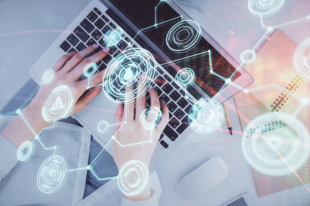 Double exposure of woman hands working on computer and social network theme hologram drawing. Top View. People connection concept.の写真素材