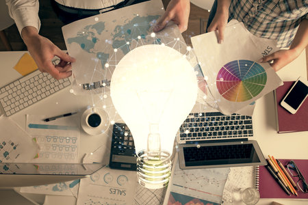 Double exposure of man and woman working together and bulb drawing. Computer background. Top View. Idea concept.の写真素材