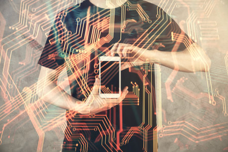 Double exposure of man's hands holding and using a digital device and tech theme hologram drawing....