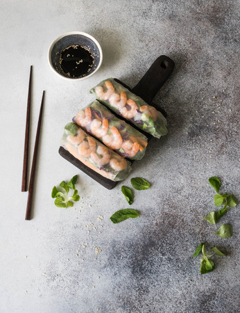 Three Vietnamese spring rolls - carrots, cucumber, corn salad, red cabbage, herbs and shrimps on a...