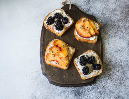 Toasts with cream cheese, peach or blackberries, thyme and honeyの写真素材