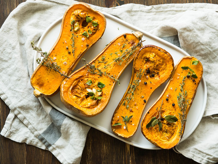 Fresh orange muscat pumpkin cut in half, baked with spices and herbの写真素材