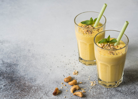 Smoothies of mango, yogurt and cashew in glassesの写真素材