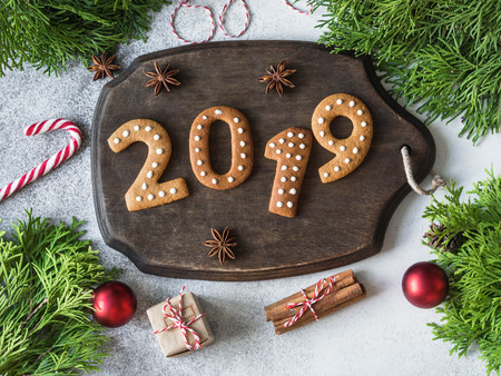 Ginger Christmas or New Year cookies in the form of numbers 2019 on a dark wood board on gray background. Seasonal packaging and New Year's attributesの写真素材