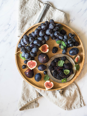 Purple fruits, berries and green mint leaves.の写真素材