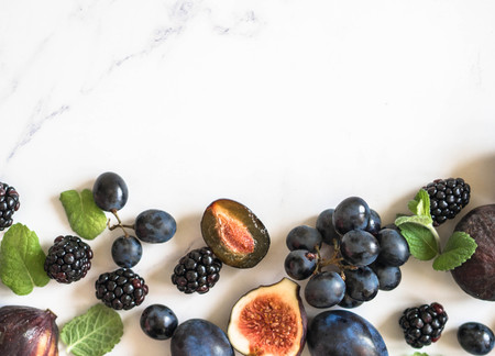 Purple fruits, berries and mint leaves border.の写真素材