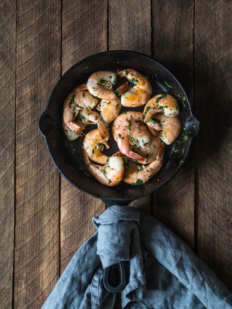 Roasted shrimps with herbs and spices on the black frying panの写真素材