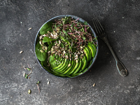 Green healthy salad of spinach, sprouts, avocados and various seedsの写真素材