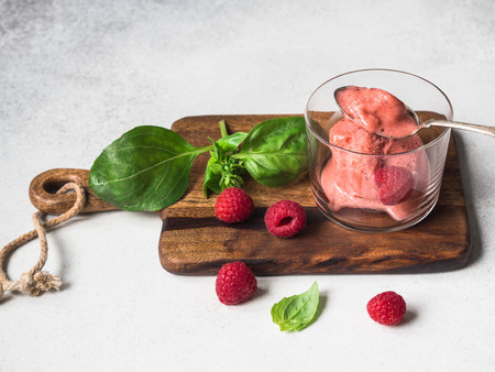 Fresh homemade sorbet basil and strawberries in glass, vintage spoon and fresh berries on wood boardの写真素材