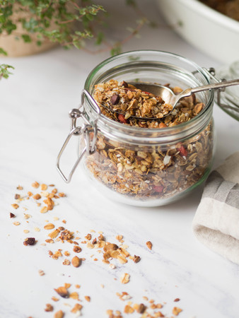 Nuts, seeds, goji berries granola in open glass jar. Healthy breakfastの写真素材