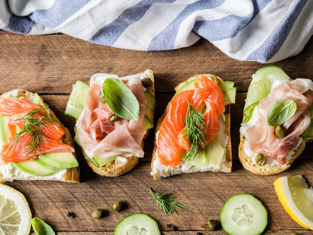 Sandwiches with cream cheese, salmon, avocado and cream cheese, prosciutto, cucumber on grilled toastsの写真素材