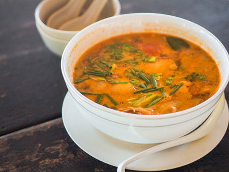 Sour and spicy Tom Yum Gong soup on a table in a restaurant.