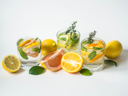 Set summer cold drinks with different citrus and herds in glasses on a whiteの写真素材
