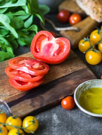Various fresh ingredients for making sandwiches - vegetables, bread, olive oil and curd cheese on a dark backgroundの写真素材