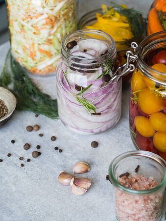 Salting various vegetables in glass jars for long-term storage.