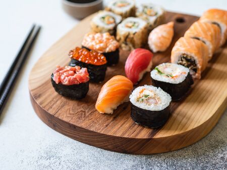 Variety of sushi, rolls and gunkan served on wood board. Shrimp, unagi, crab, salmon, tuna and red caviarの写真素材