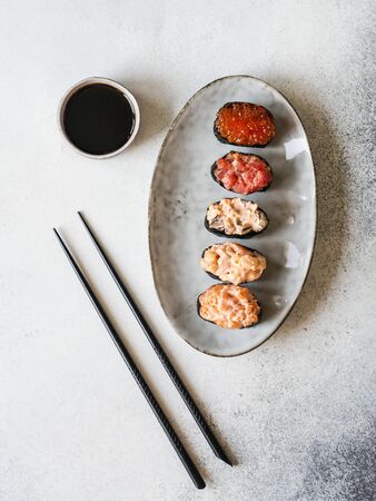 Variety gunkans with salmon, shrimp, tuna, mussels, red caviar on oval ceramic plate. Top viewの写真素材