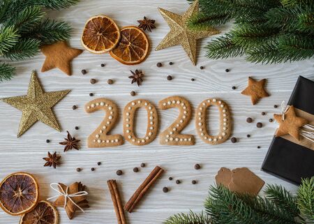 Ginger biscuits of the form of numbers and 2020 new year ginger cookies white wood background. Top view. Seasonal packaging, spices and New Year's attributesの写真素材
